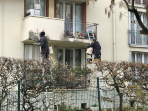 travailleurs sur 2 échelles en façade d'un immeuble